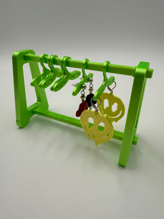 Green "Mini clothing rack" with hangers with holes for holding earrings.