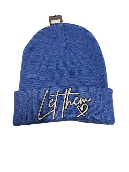 Blue beanie with 'Let them' text on a gray surface